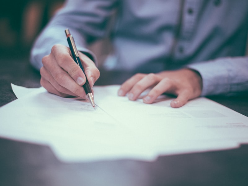 Signing contracts and compliance documents at an executive desk
