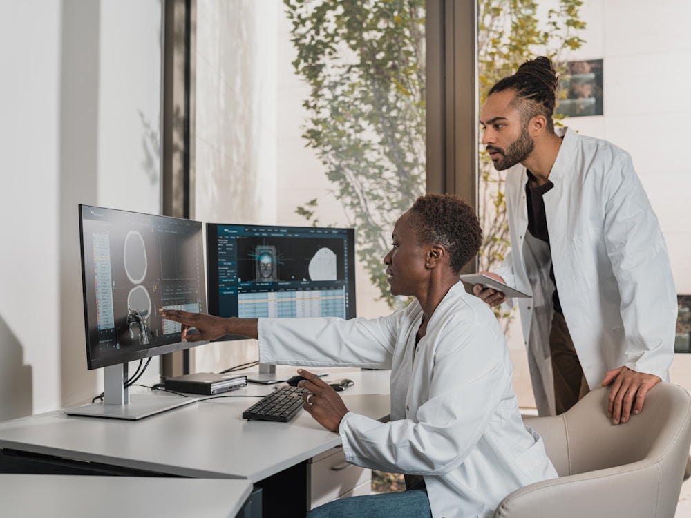 Clinicians reviewing radiation therapy imaging and treatment data on workstation monitors